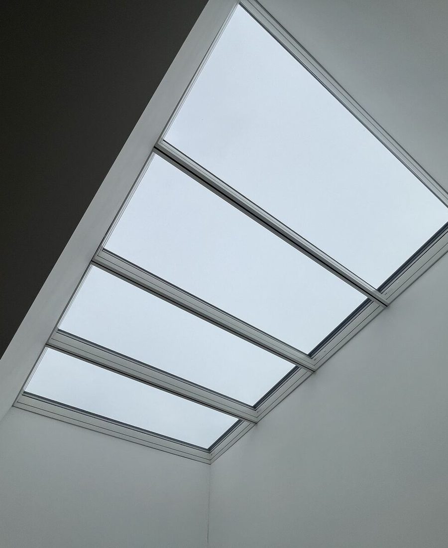 A four-panel skylight finished into a white ceiling, seen from below